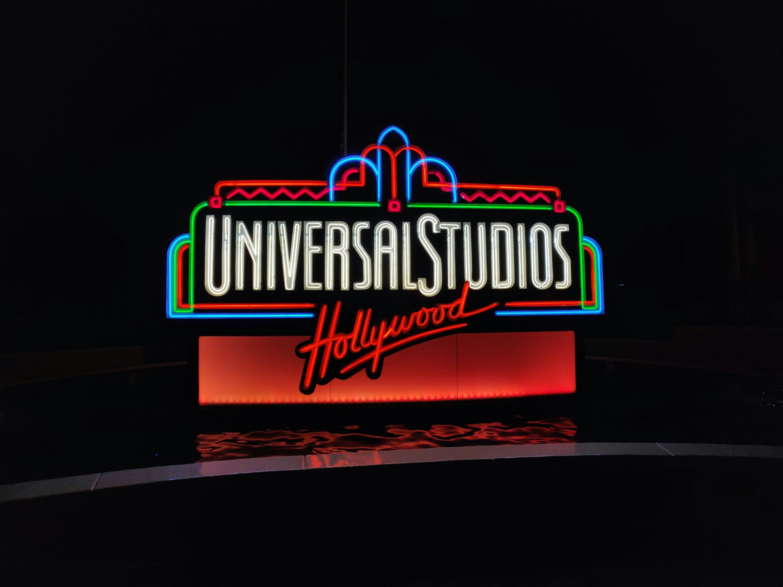 Universal Studios Hollywood logo at the theme park all lit up at night time