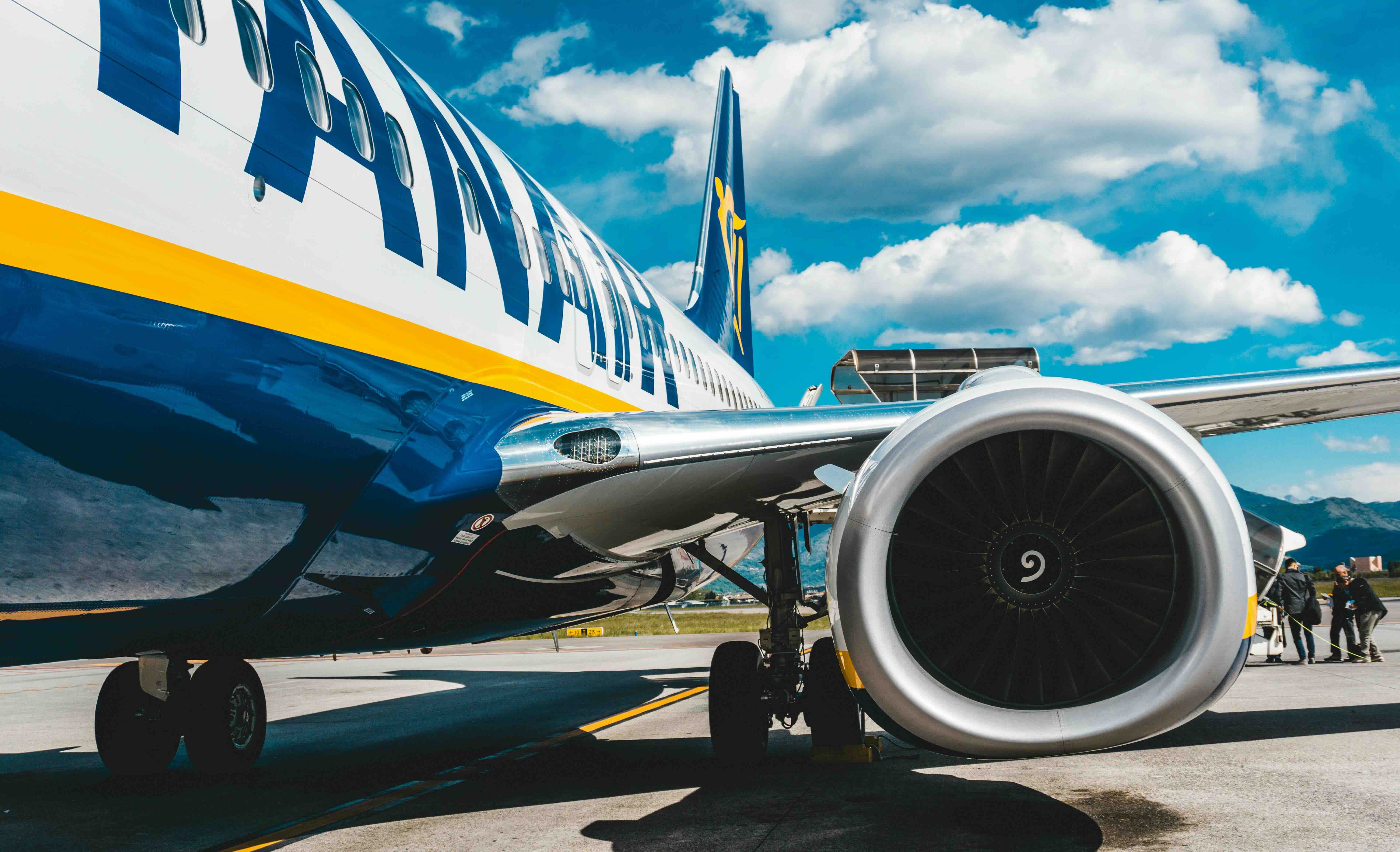 Close-up of Ryanair plane, camera is focused mostly on the wing and turbine.