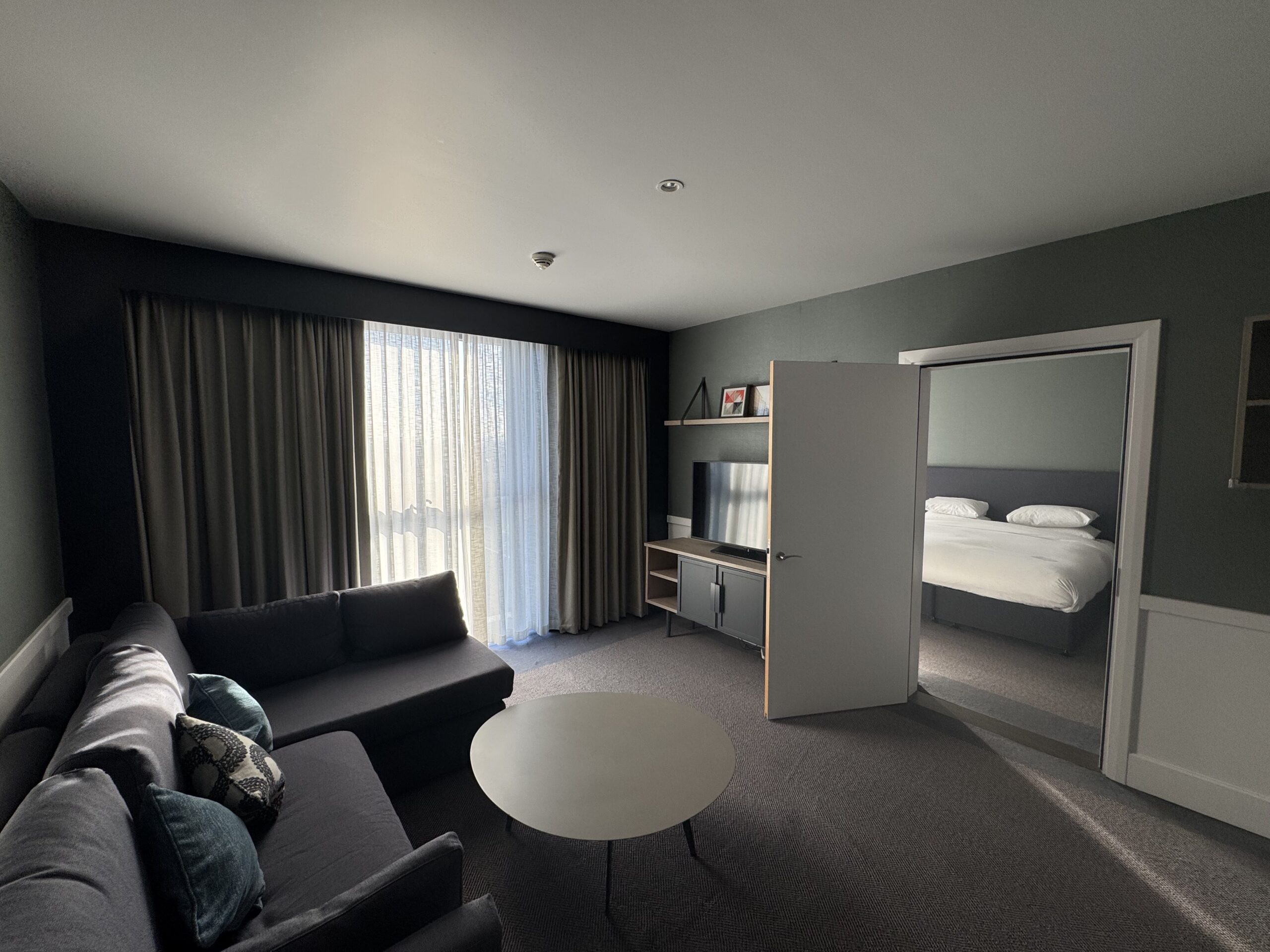 Hyatt House Manchester one bedroom suite, can see the sofa and TV then door leading into the bedroom.